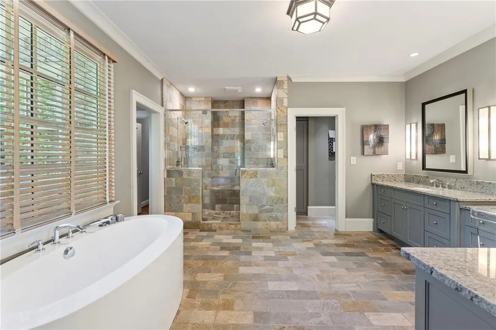 The primary bathroom is fully designed with his and hers options including dual vanities, dressing table, separate tub and shower and expansive his and hers closets that must be seen to truly appreciate!