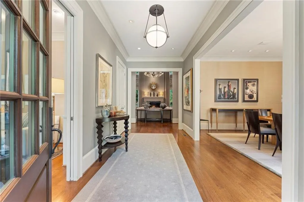 A warm entryway leads past a library on the left and dining room on the right into a dramatic two story living room.