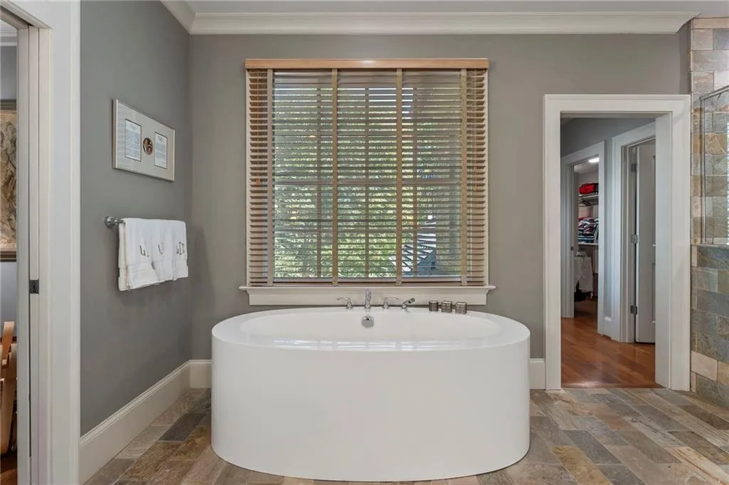 The bathroom has a large soaking tub and enormous his and her closet suites just to the right.