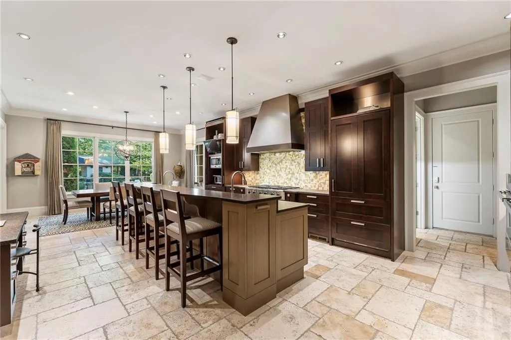 Enjoy this beautiful kitchen and the convenience of the adjacent laundry room with laundry chute. The mud room and powder room also connect to the friendship door and three garages.