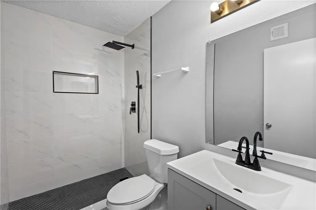 Fully updated bathroom with vanity, a shower stall.