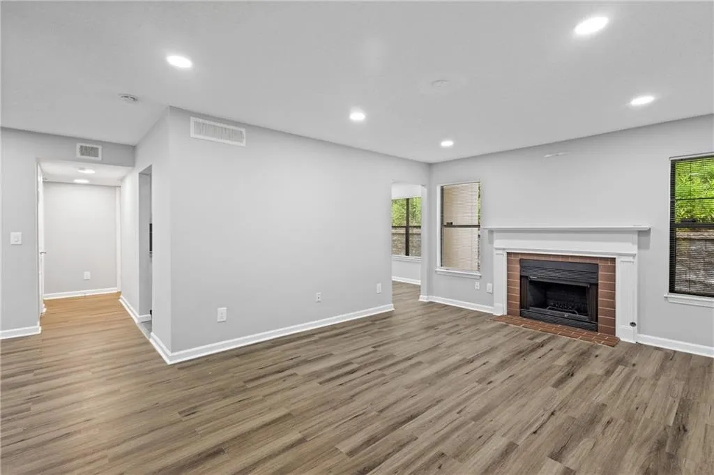 Unfurnished living room with luxury vinyl floors, recessed lighting, and a fireplace