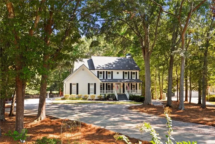 White siding exterior with a dark roof and black shutters