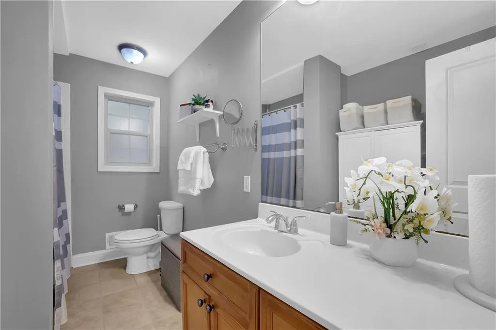 Bathroom featuring tile flooring, oversized vanity, and toilet