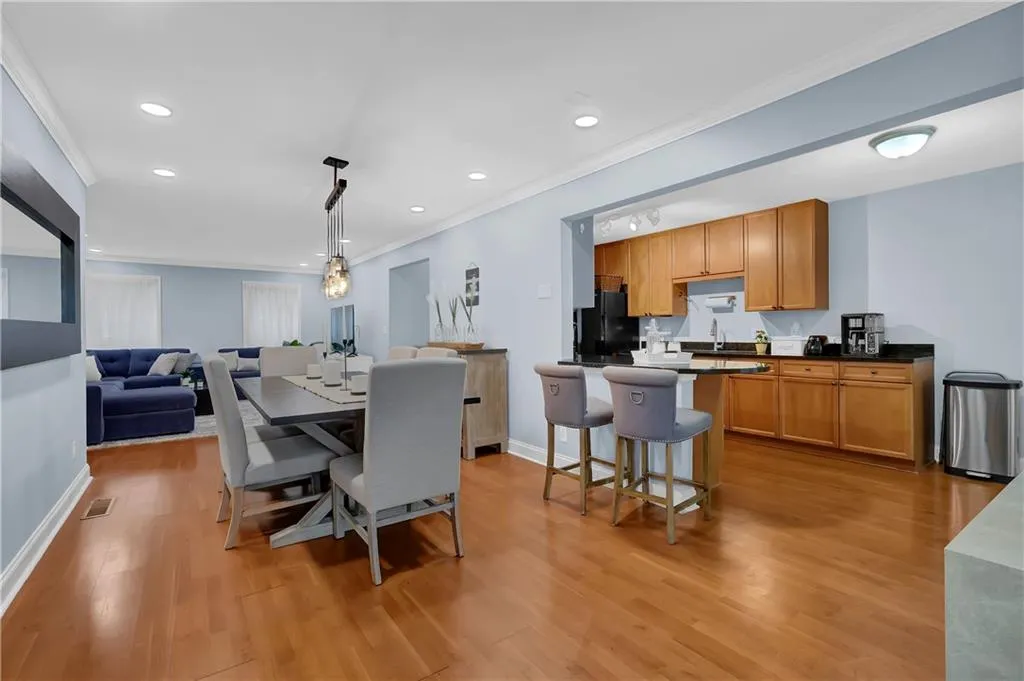Dining area with ornamental molding, sink, and light hardwood / wood-style flooring