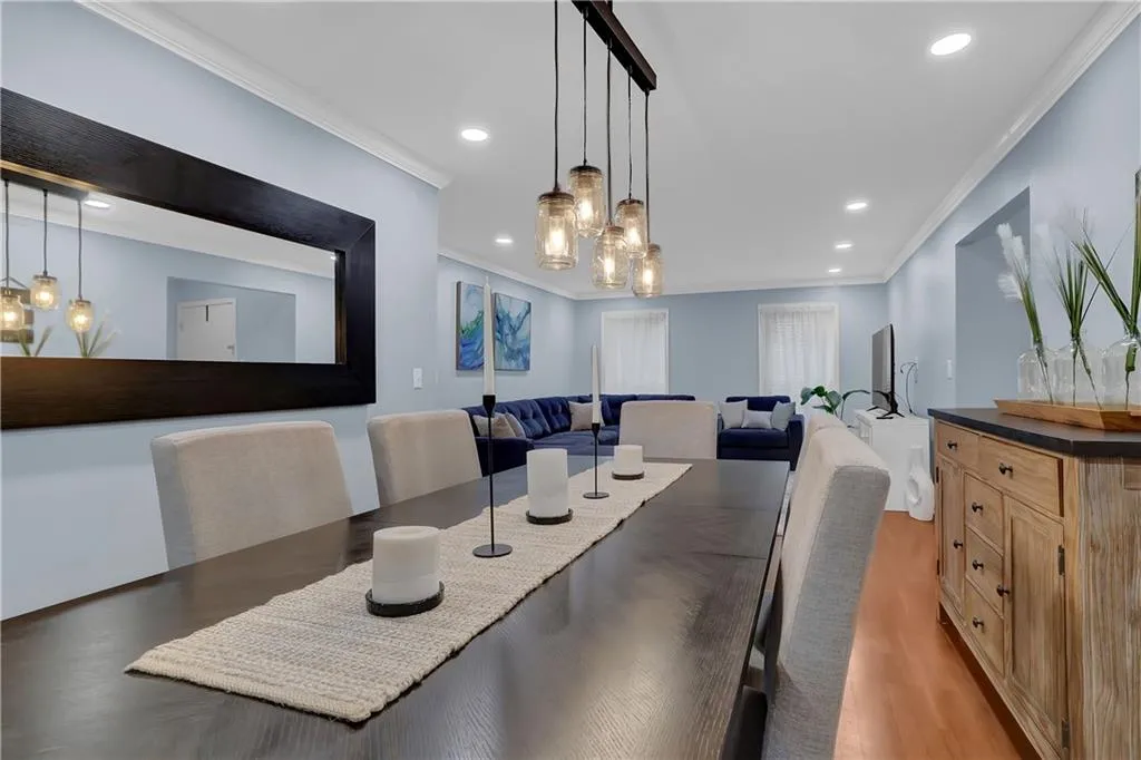 Dining room featuring ornamental molding, light wood-type flooring, and an inviting chandelier