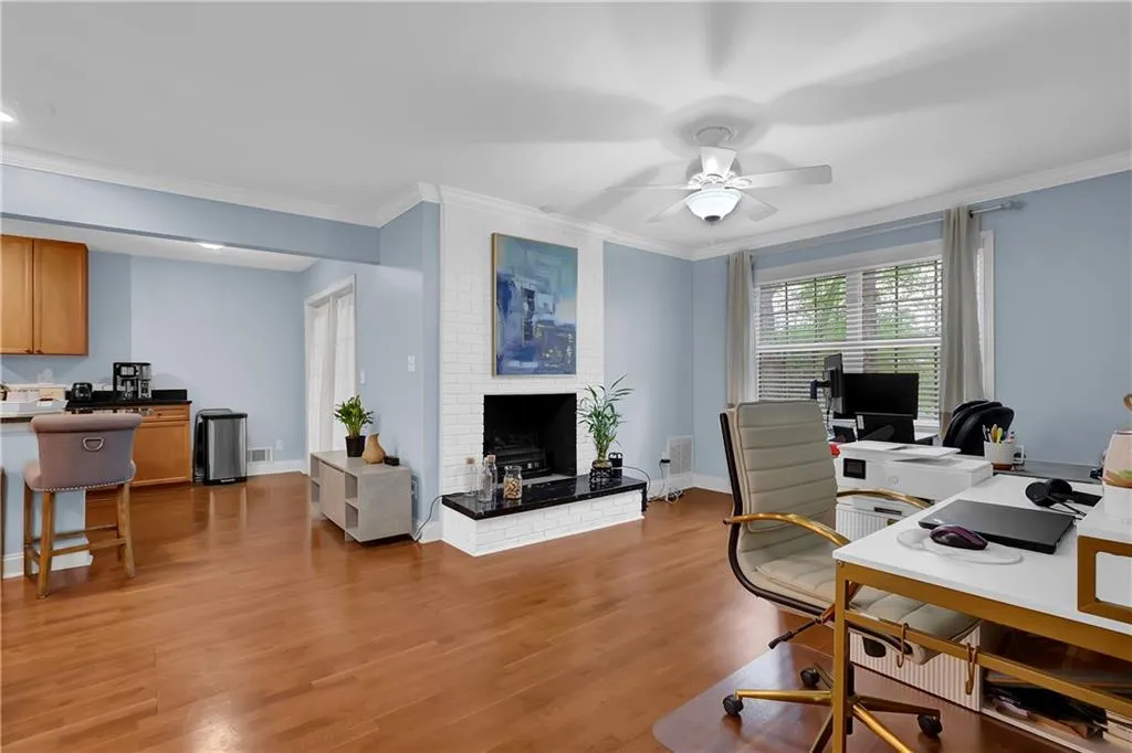 Office space featuring ornamental molding, light hardwood / wood-style floors, and ceiling fan
