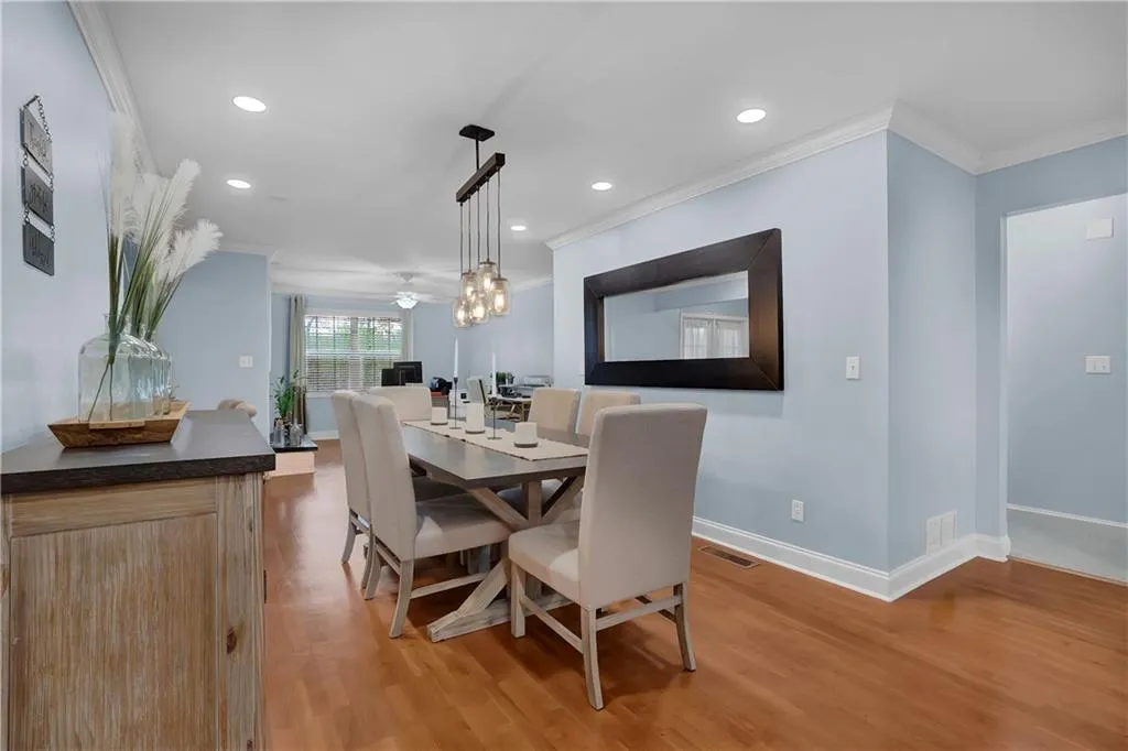 Dining room with light hardwood / wood-style flooring, ceiling fan, and ornamental molding