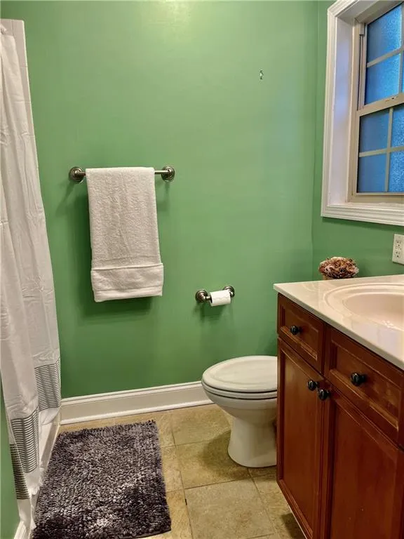 Bathroom with vanity, tile floors, and toilet