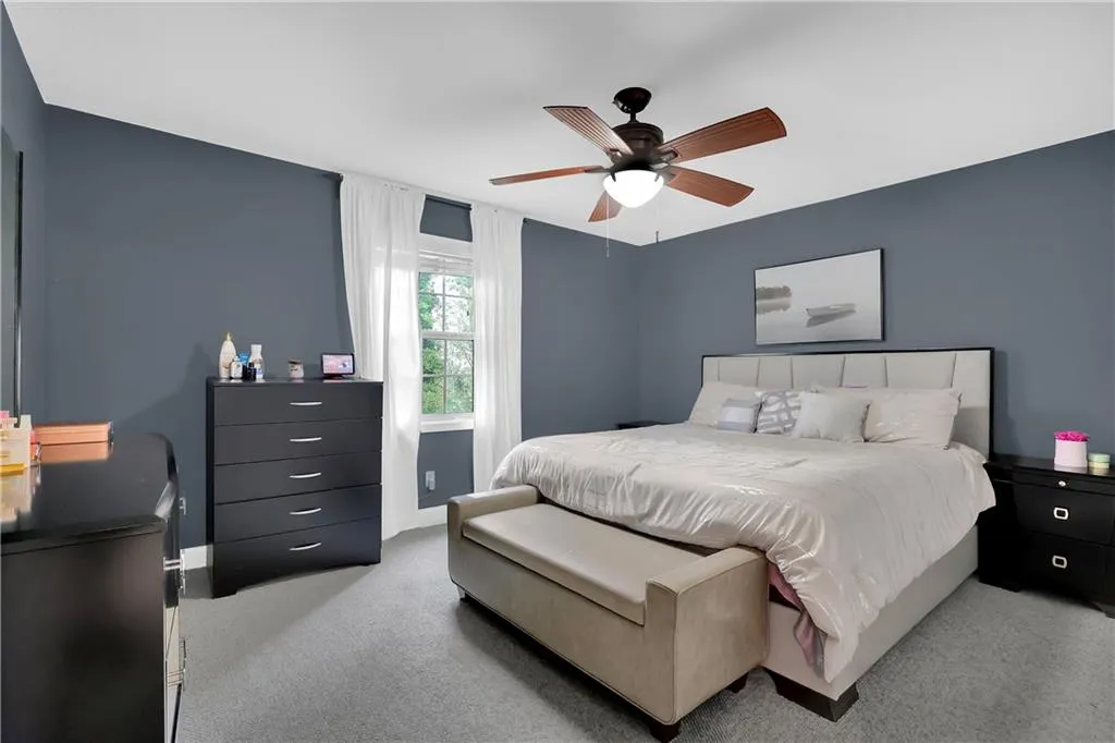 Carpeted bedroom with ceiling fan