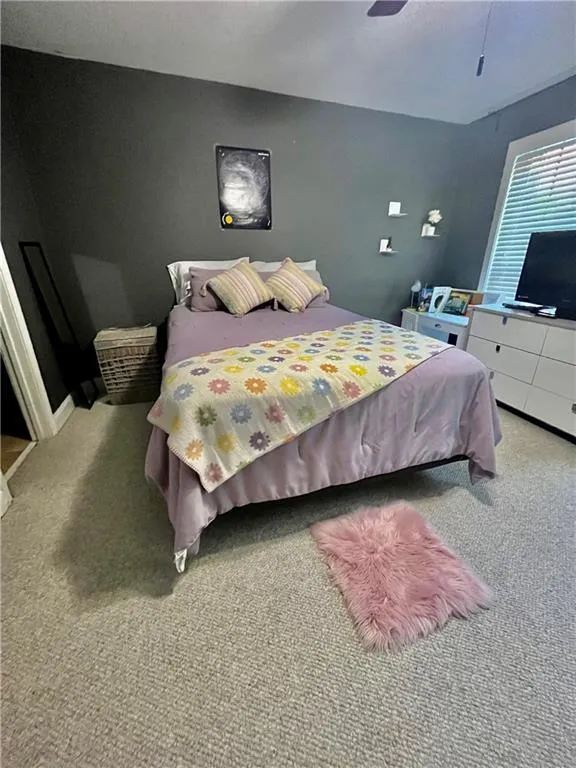 Carpeted bedroom with ceiling fan