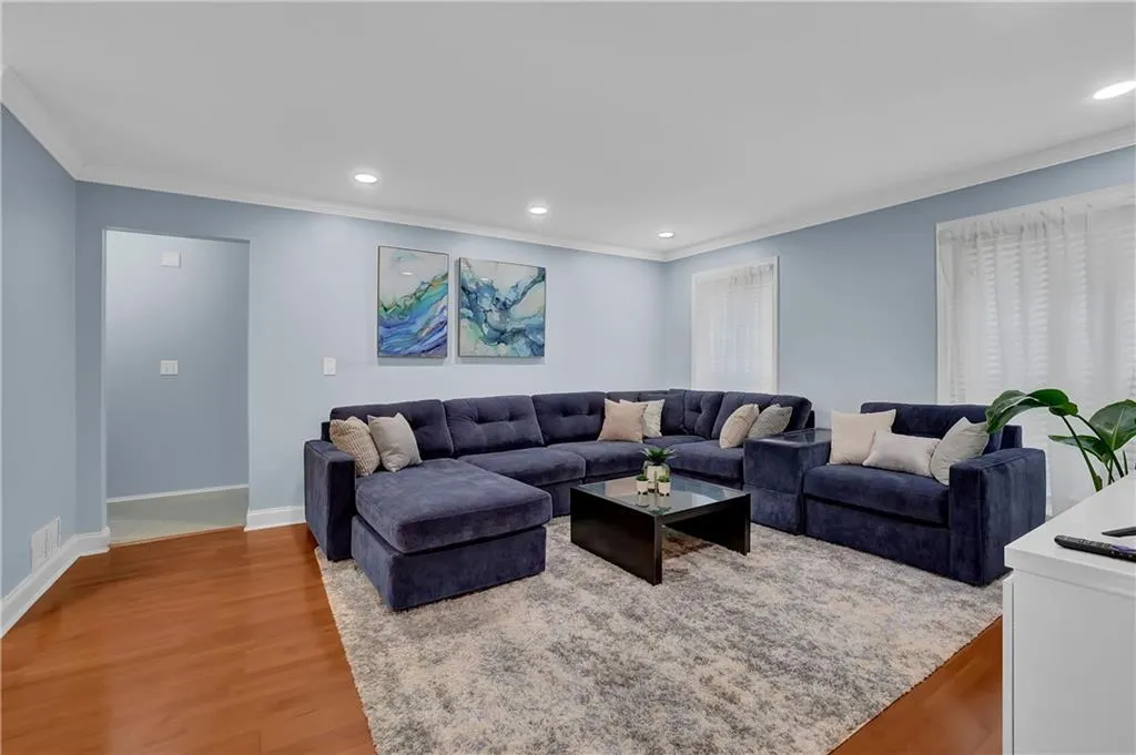 Living room featuring ornamental molding and light wood-type flooring