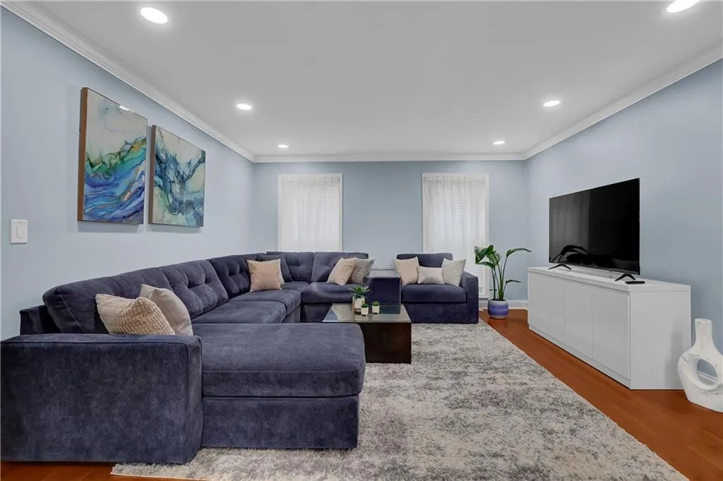 Living room featuring dark hardwood / wood-style flooring and crown molding