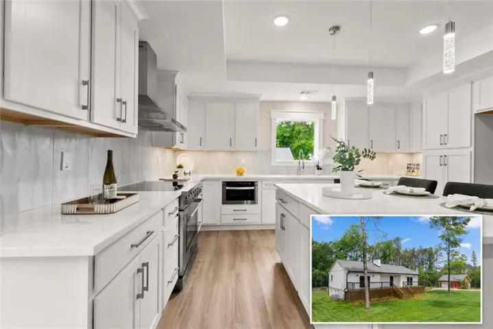 Modern kitchen featuring white shaker cabinetry, stainless steel appliances, quartz countertops, and wood-finish flooring