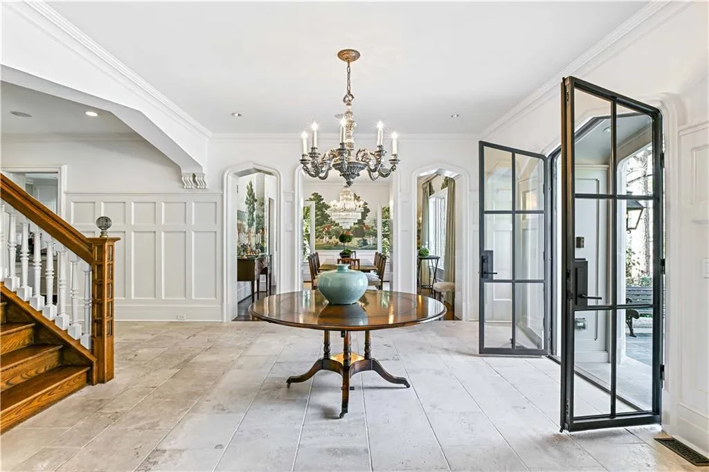 Foyer entrance featuring Chandelier, view of dining room, and wainscoting