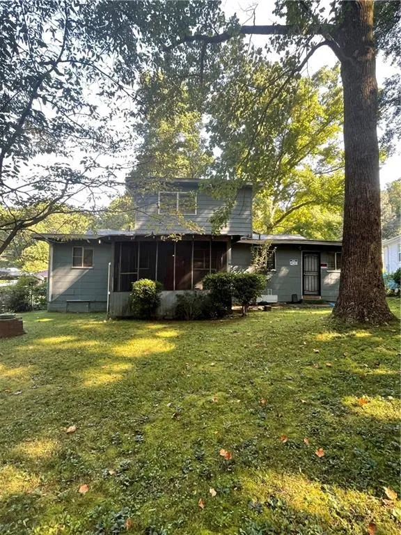 Back of house featuring a yard and a sunroom