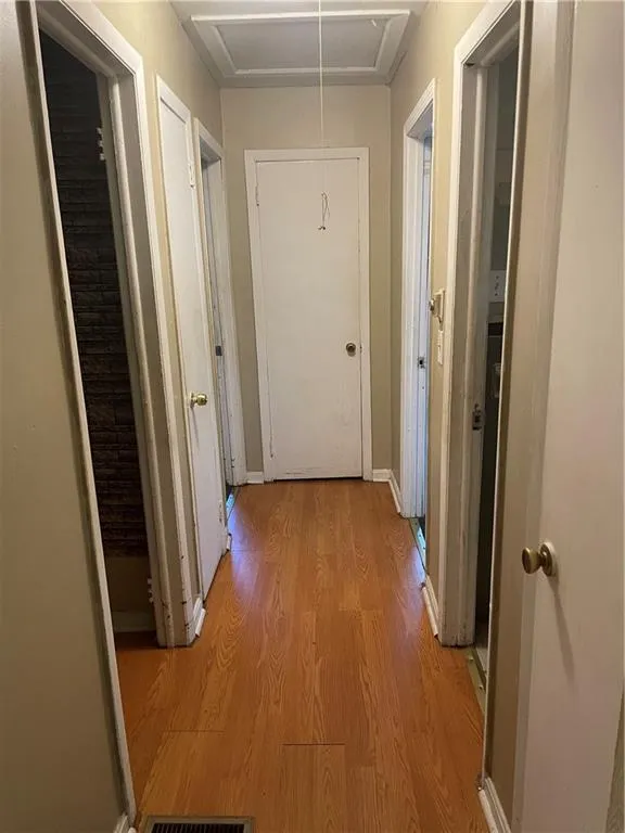 Hall featuring attic access and light wood-style flooring