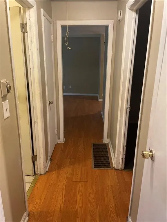 Hallway featuring light wood-style flooring and baseboards
