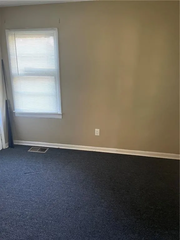 Carpeted empty room featuring baseboards