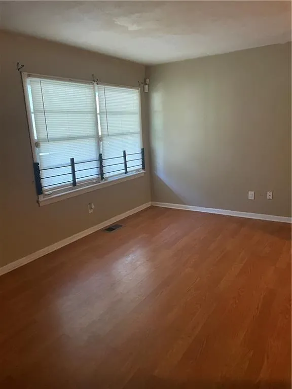 Spare room featuring wood finished floors and baseboards