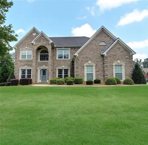Brick exterior with arched entryway, architectural gables, and multiple windows