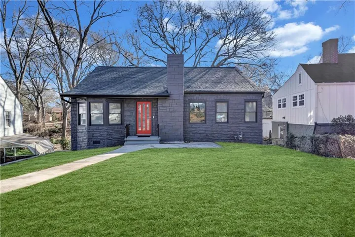 Stone veneer exterior with a red entry door