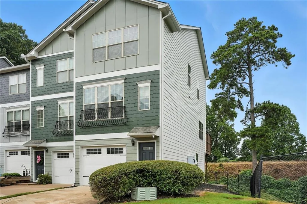 View of front facade featuring board and batten siding, a garage, and driveway