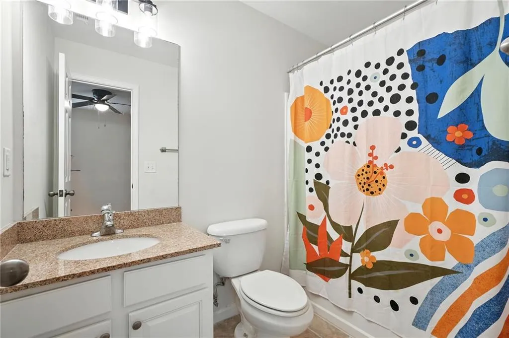 Full bathroom with vanity, a shower with shower curtain, and a ceiling fan