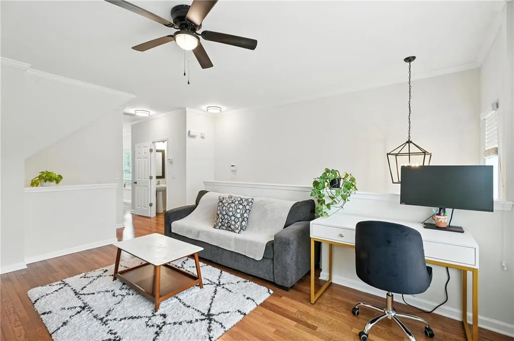 Office area with ornamental molding, wood finished floors, and ceiling fan