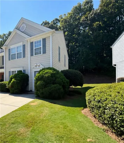Two-story exterior with horizontal siding, a gabled roofline, and decorative window shutters