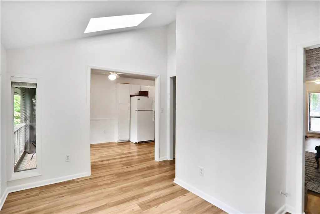 Bright and airy sunroom, with vaulted ceilings and skylights looking out to the private balcony and eat in kitchen.