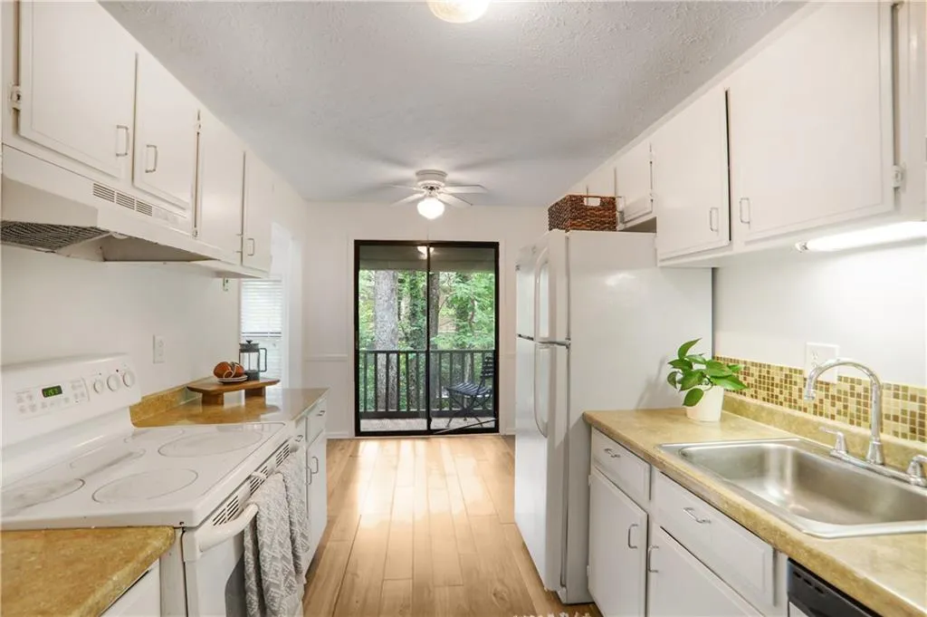 Kitchen featuring  freshly painted cabinets and laminate counters. View to the private balcony through sliding doors.