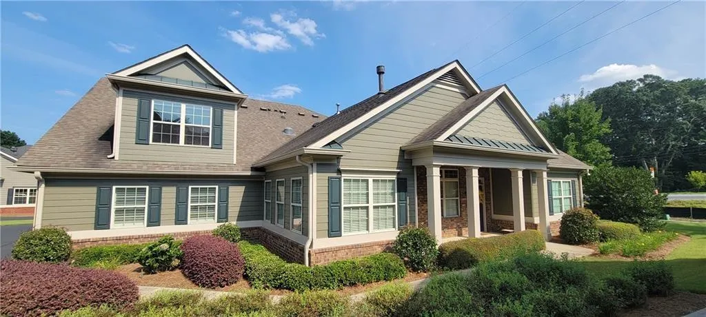 Multi-gabled exterior featuring sage green siding and brick veneer accents