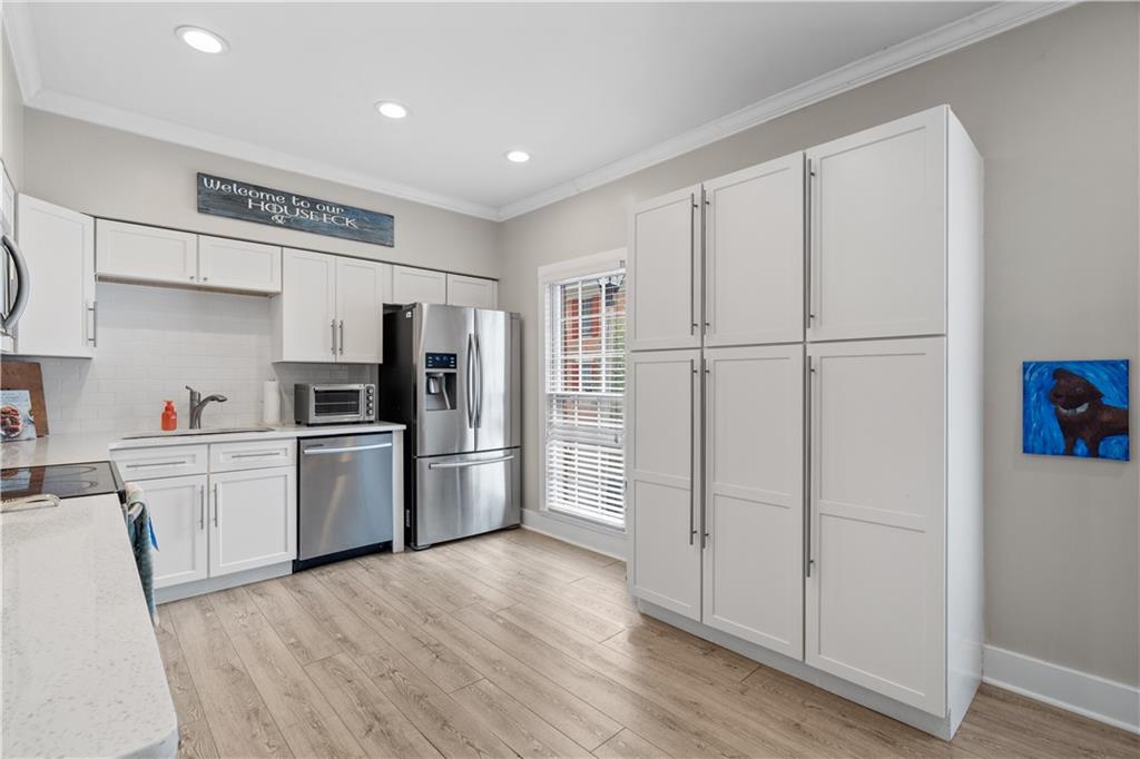Kitchen with stainless steel appliances, white cabinetry/pantry
