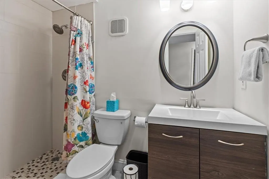 Full bath with a shower stall and vanity
