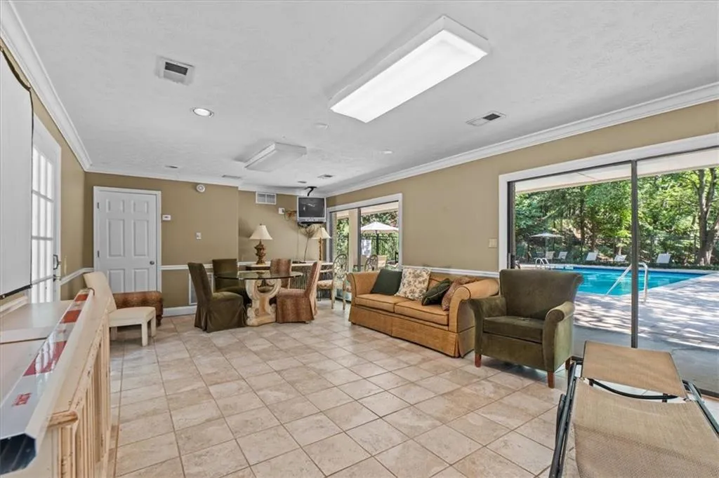 Living area featuring crown molding, healthy amount of natural light, light tile patterned flooring, and recessed lighting