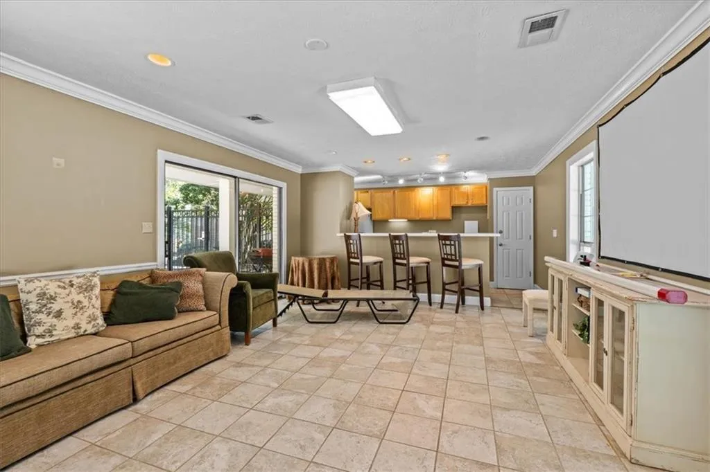 Living room featuring crown molding, light tile patterned flooring, and recessed lighting
