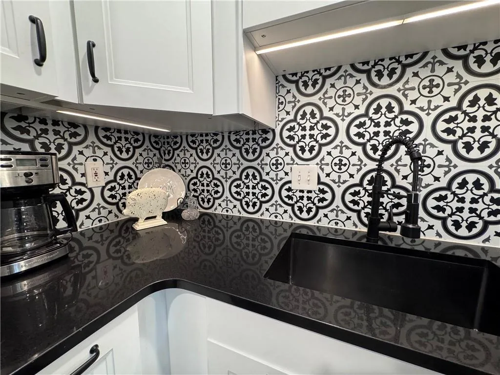 Kitchen featuring white cabinets and dark stone countertops