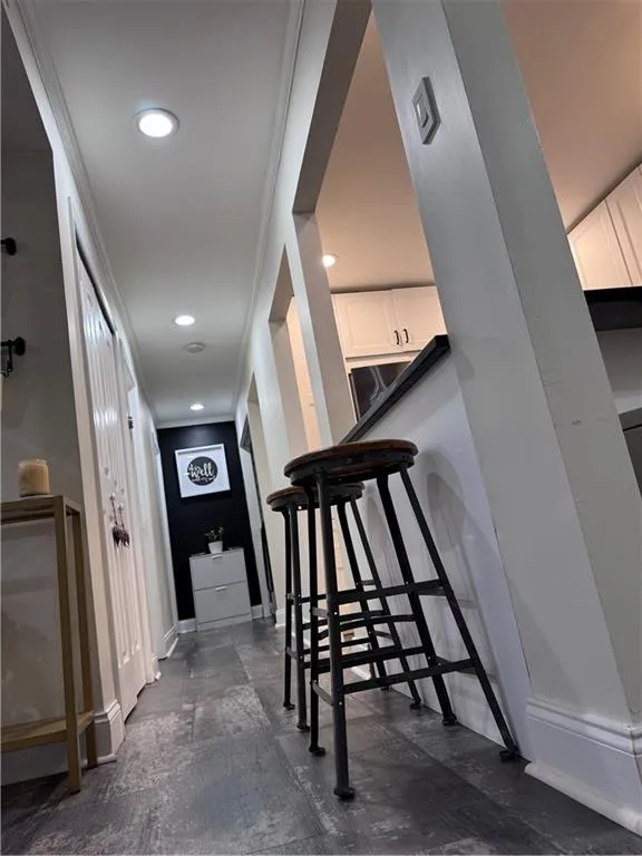 Corridor featuring raised ceilings, recessed lighting and ornamental molding