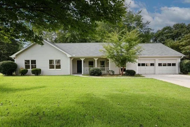 Ranch-style residence featuring light-colored siding and a covered front porch