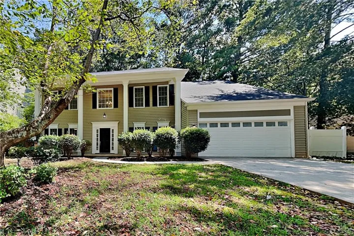 Two-story exterior with a covered entry, columned porch, and a two-car garage