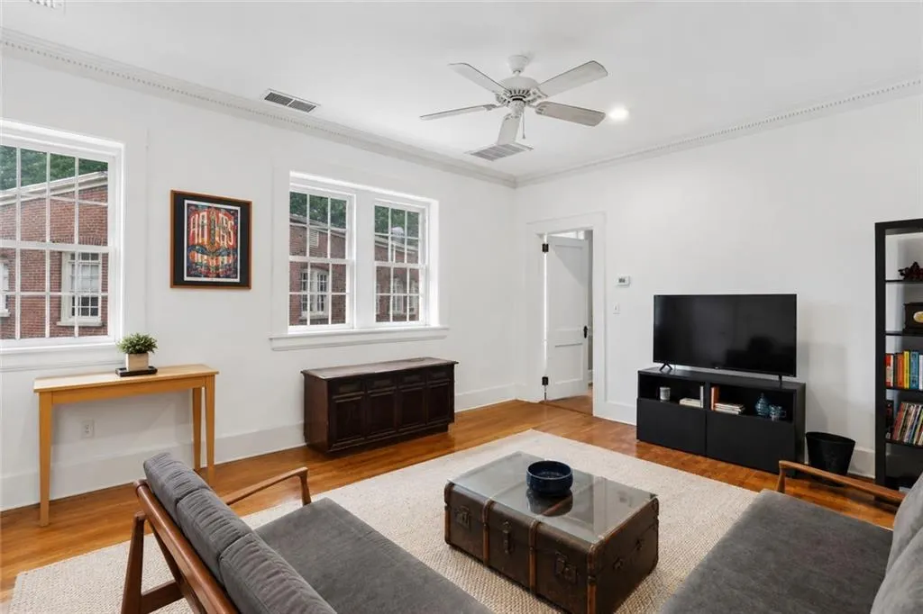 Take. note of hardwood flooring, white walls, crown molding and white paned windows. Staging digitally edited.