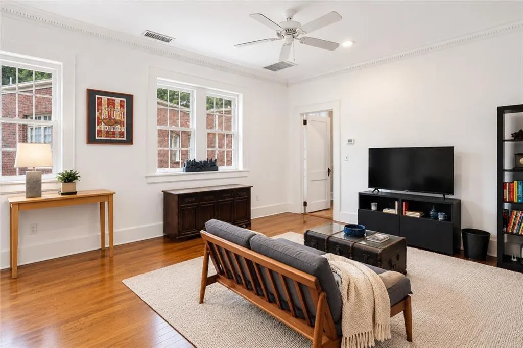 Gleaming hardwood floors and natural light! A pleasant place to entertain guests or relax with a book or a show. Staging digitally edited.