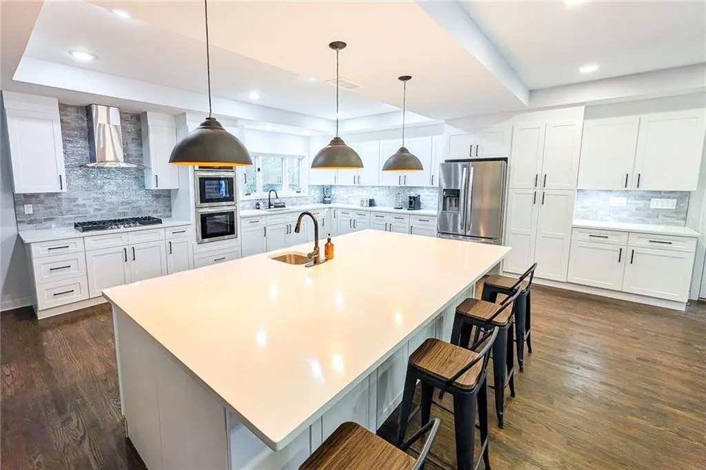 Kitchen featuring a raised ceiling, white cabinetry, tasteful backsplash, appliances with stainless steel finishes, and recessed lighting