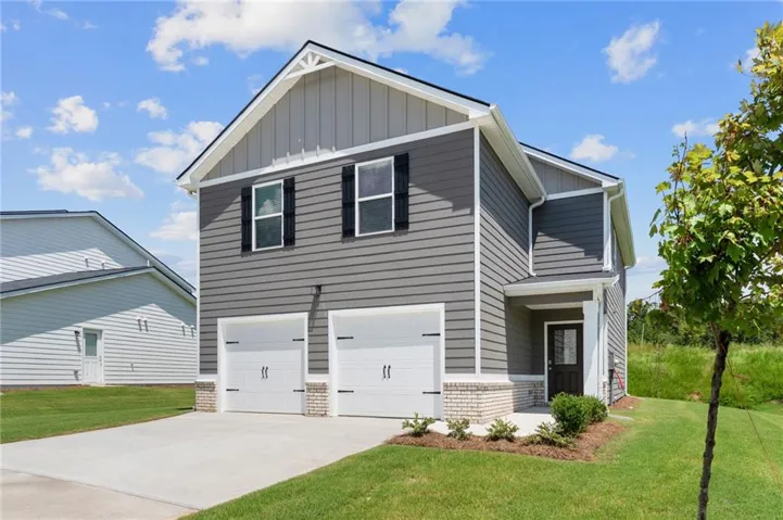 Two-story residence featuring grey siding, white trim, and a gabled roofline