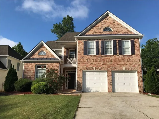 Brick exterior with gabled roof lines, white shutters, and a two-car garage