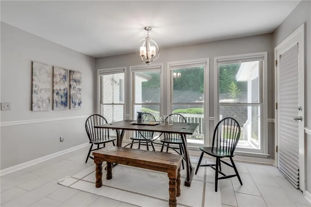Dining room with a notable chandelier, a wealth of natural light, and light tile patterned floors