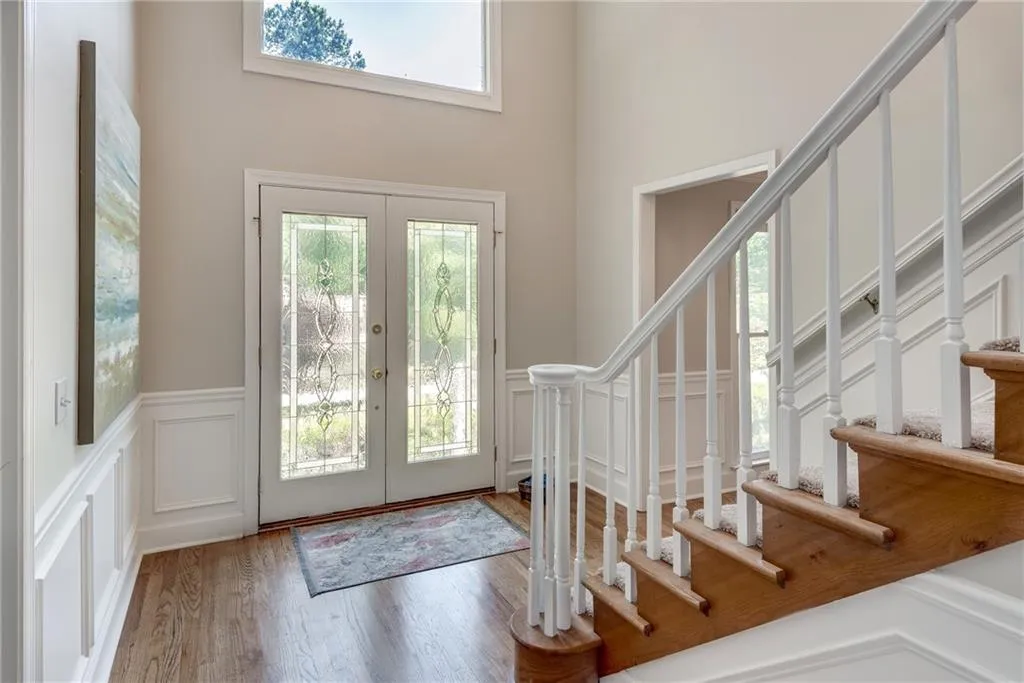Foyer featuring french doors, hardwood / wood-style floors, and a towering ceiling