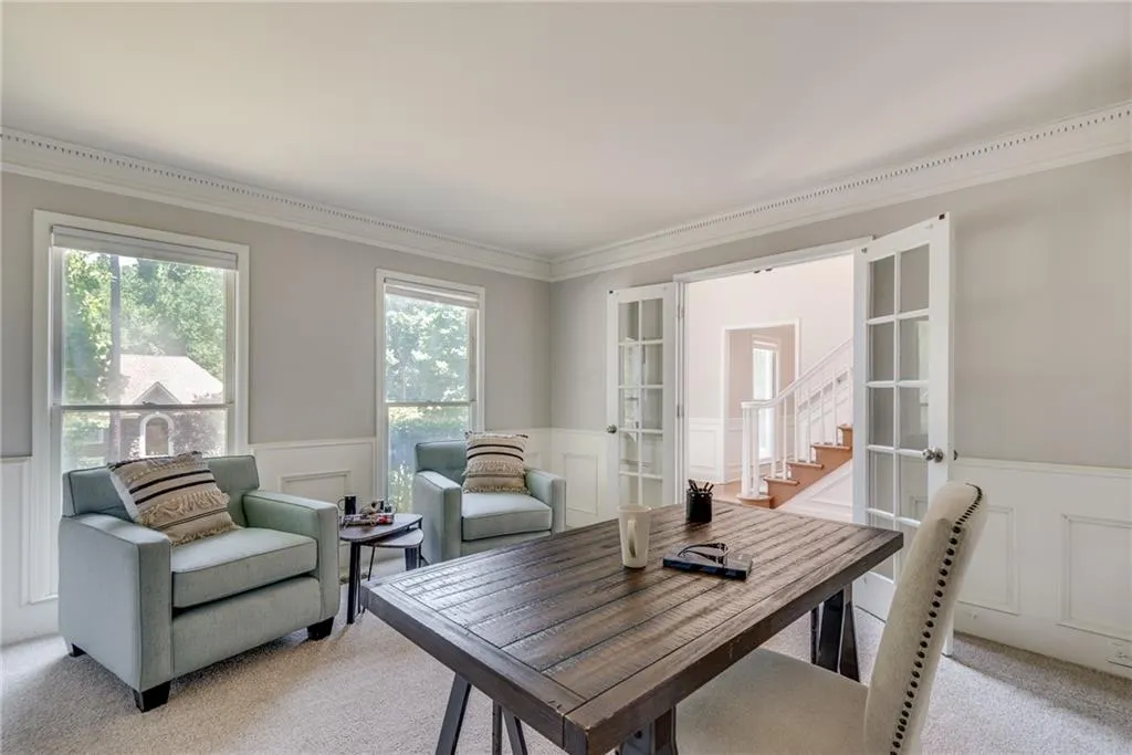 Dining space featuring french doors, carpet, and ornamental molding