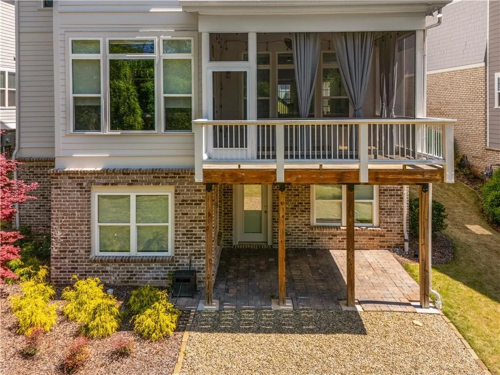 Back of house with a patio, brick siding, and a sunroom